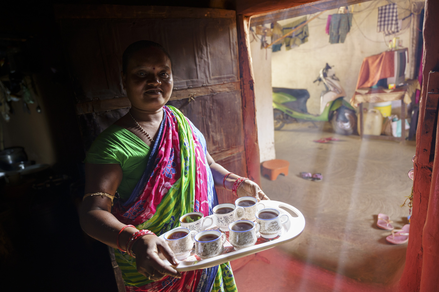 Baumwollbäuerin Falame mit einem Tablett Chai. 