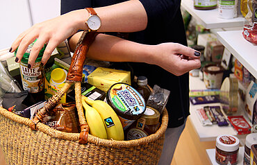 In einem Bastkorb liegen viele verschiedene Fairtrade-Produkte. 