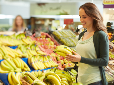 Konsumentin mit Fairtrade-Bananen im Supermarkt