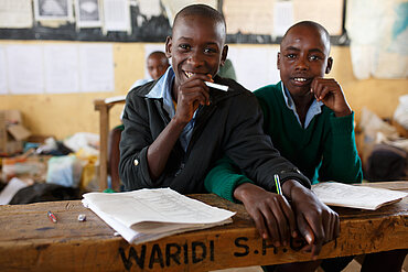 Zwei Jugendliche sitzen auf der Schulbank