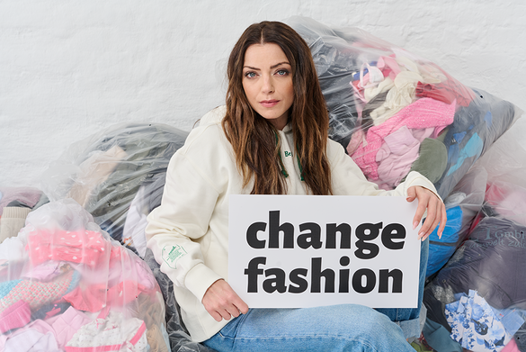 Anne menden mit Schild: Change Fashion. Bild: Fairtrade / C. Köstlin