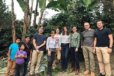 ALDI und Fairtrade-Teams gemeinsam mit einer Kaffeebäuerin und ihrer Familie