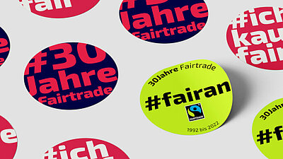 Runde Sticker mit bunten Aufschriften wie "30 Jahre Fairtrade", "#ichkaufefair" oder "#fairan" 