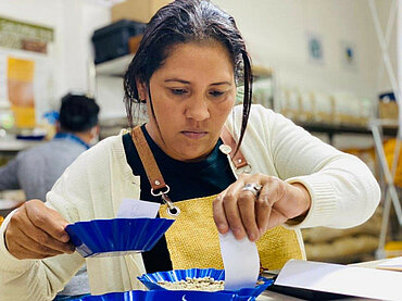 Frau präpariert Kaffeebohnen für Verköstigung im Rahmen des Wettbewerbs Taza Dorada in Guatemala