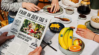 #FairerAufbruch | #FairInDenTag | Frau hält Frühstückszeitung