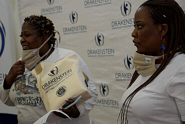 Musa und Thembi aus Drakenstein verteilen Beutel mit fair gehandelten Produkten.