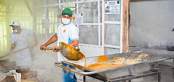 Victor Guevara, Betreiber der Mühle, füllt den gekochten Zuckersud in Mischbecken.
