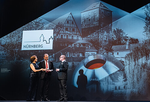 Nürnbergs Oberbürgermeister Dr. Ulrich Maly nimmt die Auszeichnung von Malu Dreyer und Stefan Schulze-Hausmann entgegen.